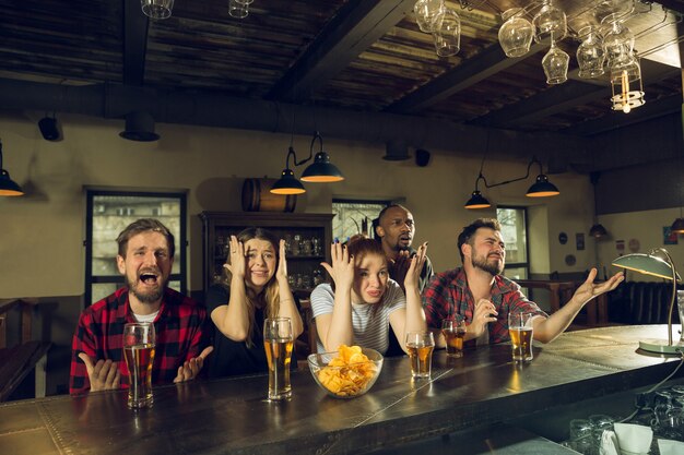 Gli appassionati di sport tifano al bar, pub e bevono birra mentre il campionato, la competizione sta andando