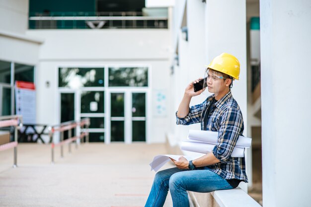 Gli architetti tengono le planimetrie e parlano al telefono.