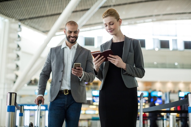 Gli imprenditori in attesa in coda al banco del check-in con i bagagli