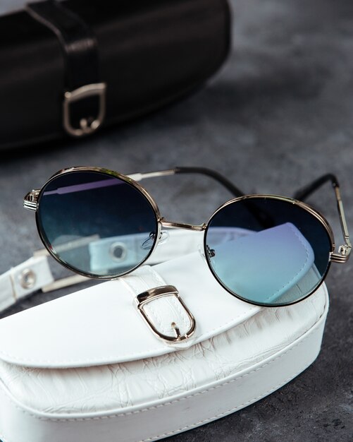 Gli occhiali da sole blu moderni di una vista superiore sui precedenti grigi hanno isolato l'eleganza degli occhiali di visione