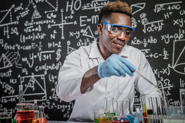 Gli scienziati gettano sostanze chimiche nel bicchiere in laboratorio