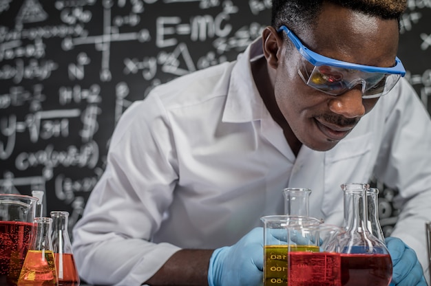 Gli scienziati guardano i prodotti chimici in vetro in laboratorio