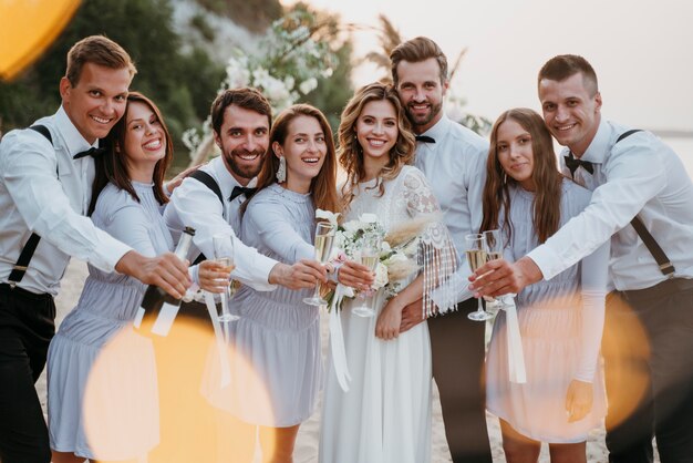 Gli sposi festeggiano il loro matrimonio con gli ospiti sulla spiaggia