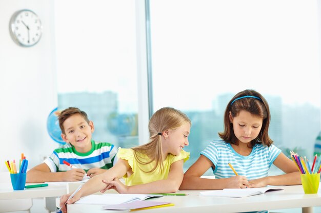 Gli studenti che studiano a banchi in aula