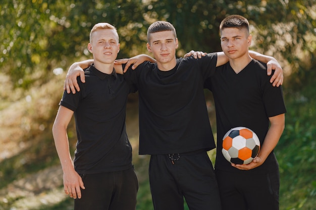 Gli uomini giocano a socer al parco. Torneo su mini-footbal. Ragazzo in tuta sportiva nera.