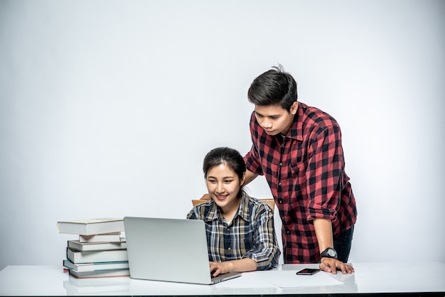 Gli uomini insegnano alle donne come lavorare con i laptop al lavoro.