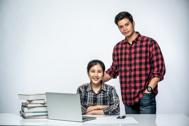 Gli uomini insegnano alle donne come lavorare con i laptop al lavoro.