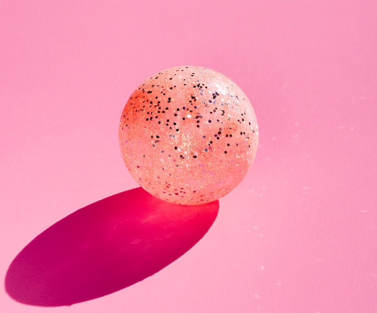 Foto gratuito globo glitter su sfondo rosa