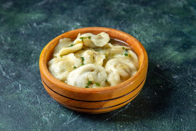 Gnocchi di carne gustosi vista frontale all'interno del piatto di legno sulla superficie scura