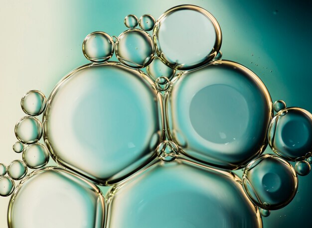 Gocce dell'olio del primo piano su una priorità bassa dell'estratto della superficie dell'acqua