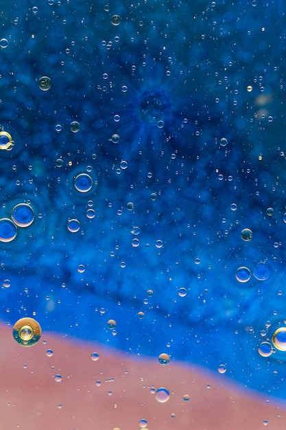 Goccioline di olio sulla superficie dell&#39;acqua colorata