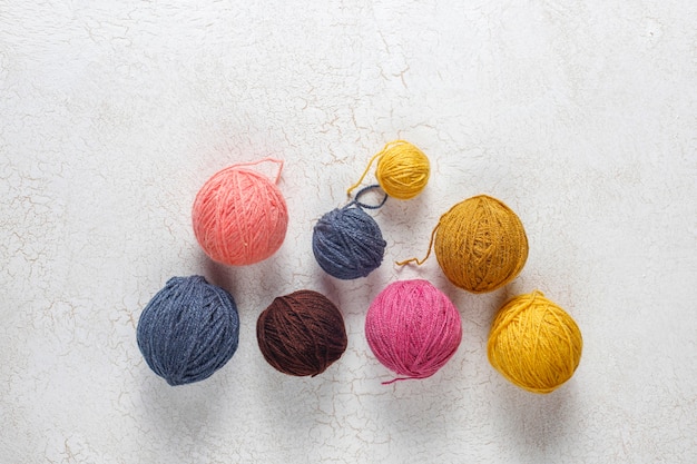 Gomitoli di filato in diversi colori con ferri da maglia.