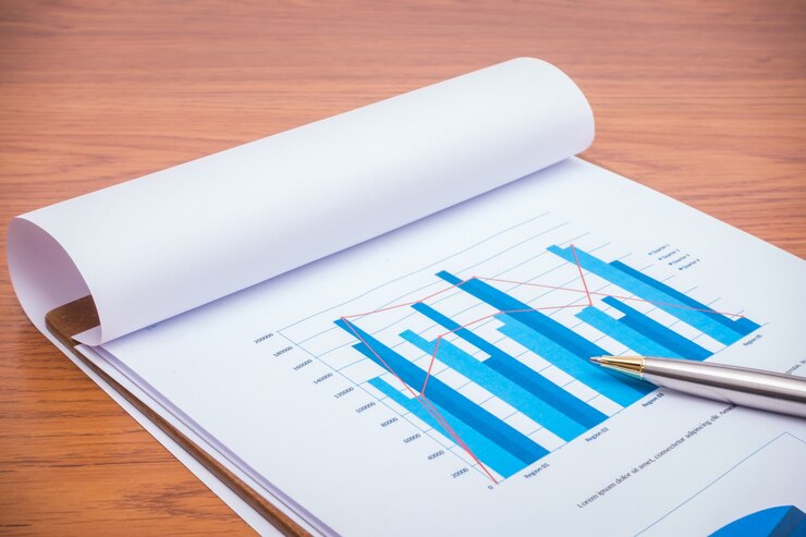 Foto gratuito grafici finanziari con la penna sul tavolo
