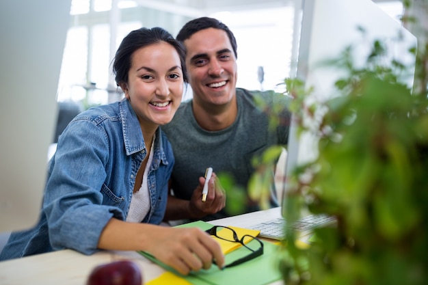 grafici Maschio e femmina sorridente in ufficio