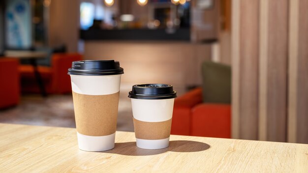 Grande e piccola tazza di caffè su un tavolo di legno in un caffè. Idea di riciclaggio