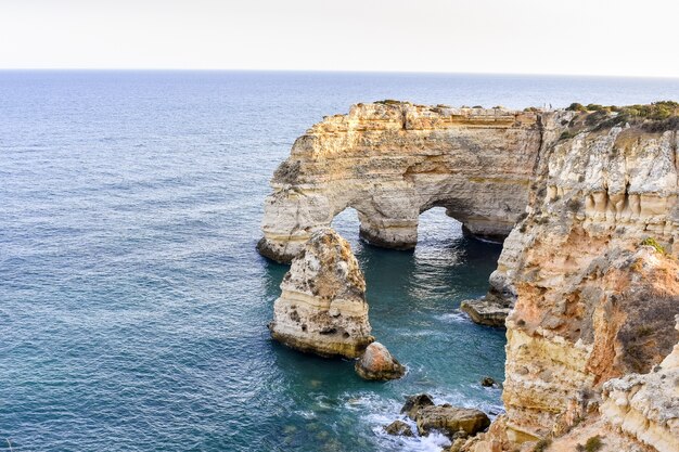 Grandi scogliere che spuntano dall'acqua durante il giorno