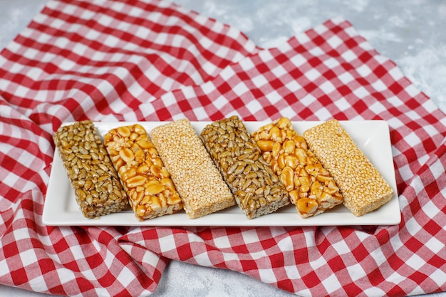 Granola bar. Spuntino dolce dessert sano. Sesamo, arachidi, girasole nel miele. Gozinaki è cibo nazionale georgiano, dolce orientale. Vista dall'alto su cemento