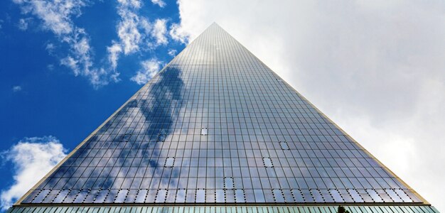 Grattacielo triangolo e cielo nuvoloso