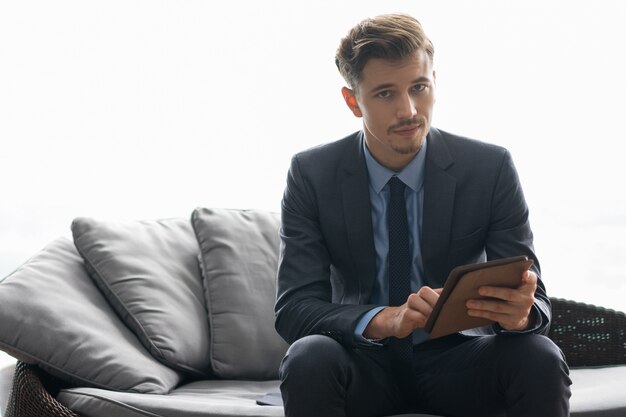 Grave Giovane riuscito uomo utilizzando tablet computer