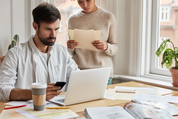 Grave web designer uomo concentrato che lavora a casa