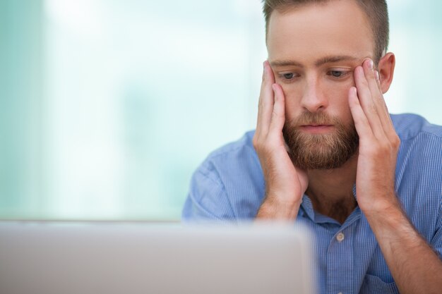 Gravi manager seduto al computer portatile dello stress