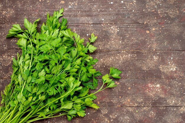 Greenies verdi di vista superiore freschi e maturi sulla foglia marrone e verde dell'insalata