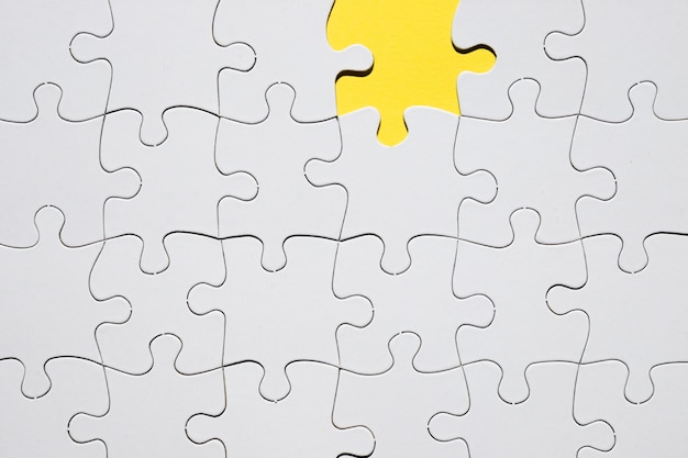 Griglia bianca del puzzle con il pezzo mancante di puzzle