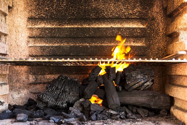 Griglia per barbecue vuota con bricchette di carbone caldo