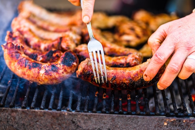 Grigliare salsicce e braciole di maiale sulla griglia del barbecue. BBQ nel g