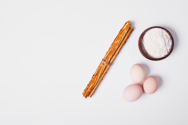 Grissini con ingredienti su bianco.