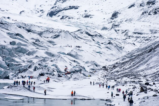 Gruppi di turisti escursionisti trekking nelle aspre montagne innevate bianche