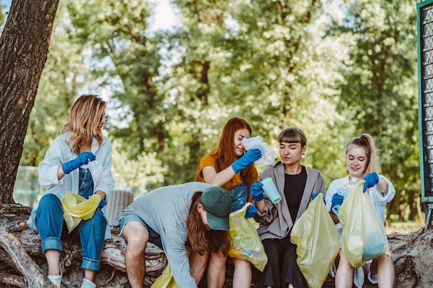 Gruppo di amici attivisti che raccolgono rifiuti di plastica al parco. Conservazione dell'ambiente.