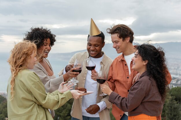 Gruppo di amici che brindano con bicchieri di vino durante la festa all'aperto