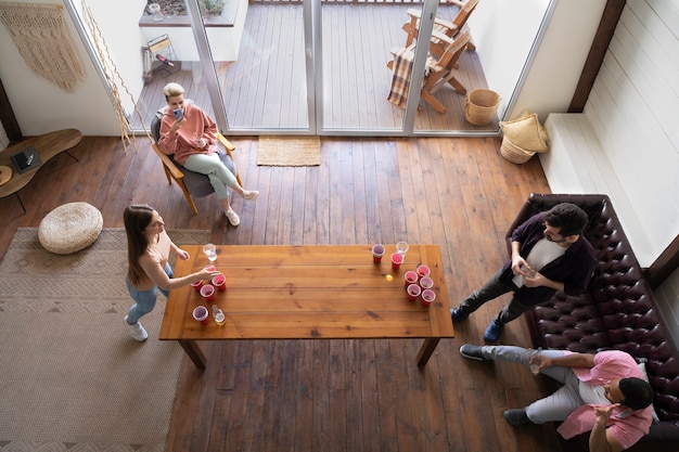 Gruppo di amici che giocano a beer pong insieme a una festa