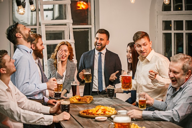 Gruppo di amici che godono di un drink serale con la birra