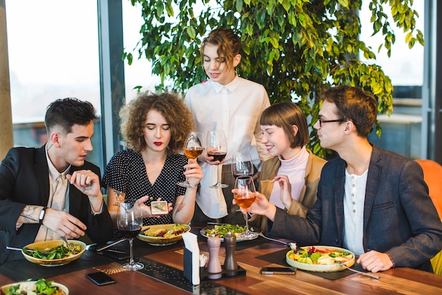 Gruppo di amici che mangiano nel ristorante