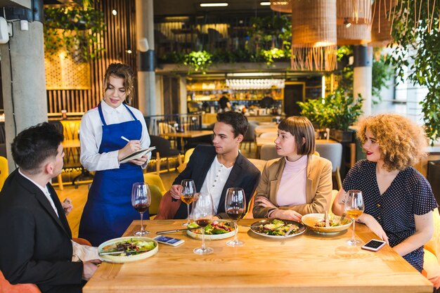 Gruppo di amici che mangiano nel ristorante