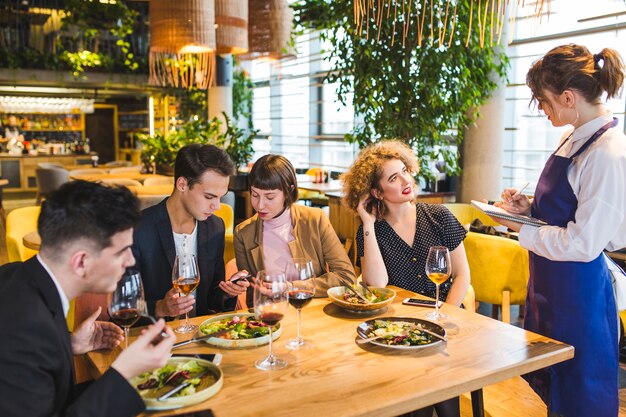 Gruppo di amici che mangiano nel ristorante