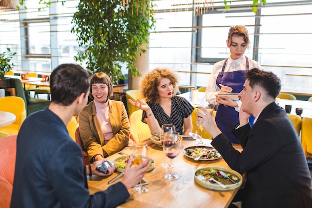 Gruppo di amici che mangiano nel ristorante