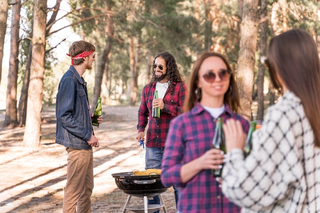 Gruppo di amici che mangiano un barbecue con birre