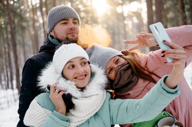 Gruppo di amici che prendono selfie all'aperto in inverno