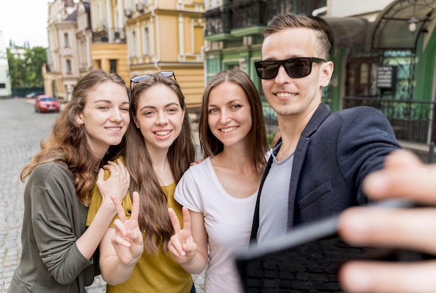 Gruppo di amici che prendono selfie all'aperto