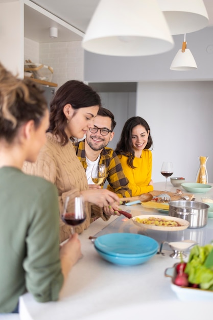 Gruppo di amici che preparano il pasto in cucina