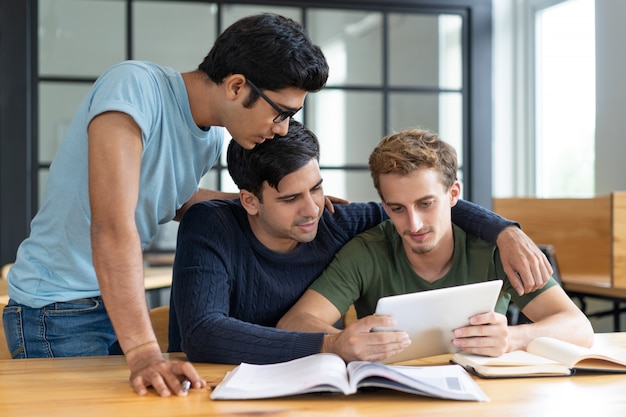 Gruppo di amici che studiano insieme, aiutandosi a vicenda