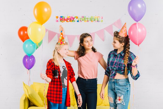 Gruppo di amici che tengono palloncini colorati durante il compleanno