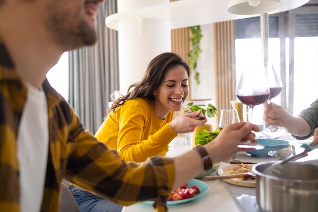 Gruppo di amici che tostano con il vino in cucina