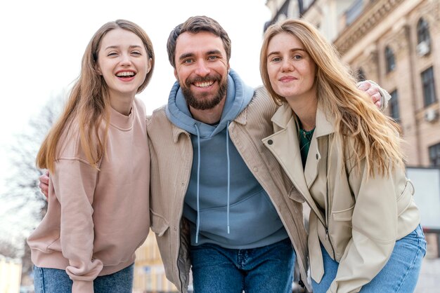 Gruppo di amici di smiley all'aperto nella città che propongono insieme