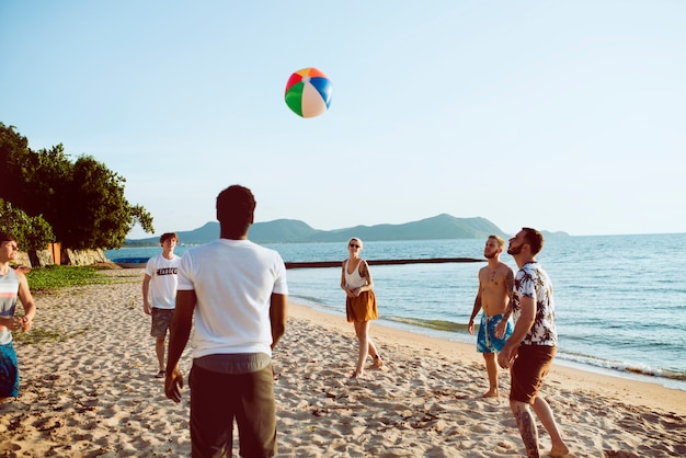 Gruppo di amici diversi che giocano insieme il beach ball