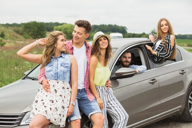 Gruppo di amici felici che godono insieme in viaggio su strada