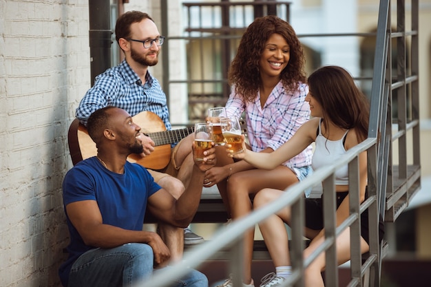 Gruppo di amici felici che hanno festa della birra in giornata estiva.